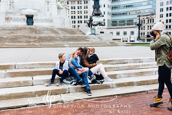 Attractive young family sitting on steps in front of Soldiers and Sailors Monument in Indianapolis IN