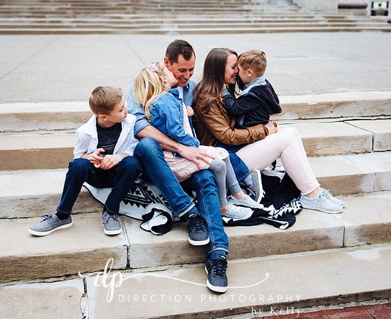 Attractive young family sitting on steps in front of Soldiers and Sailors Monument in Indianapolis IN