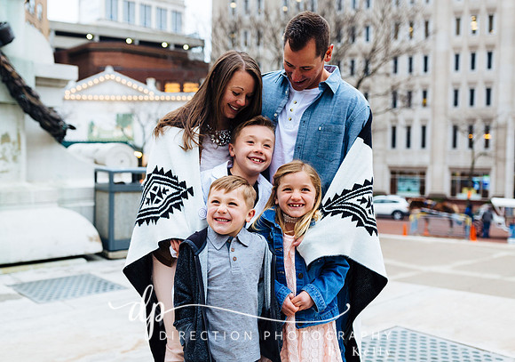 Attractive young family standing on steps in front of Soldiers and Sailors Monument in Indianapolis IN