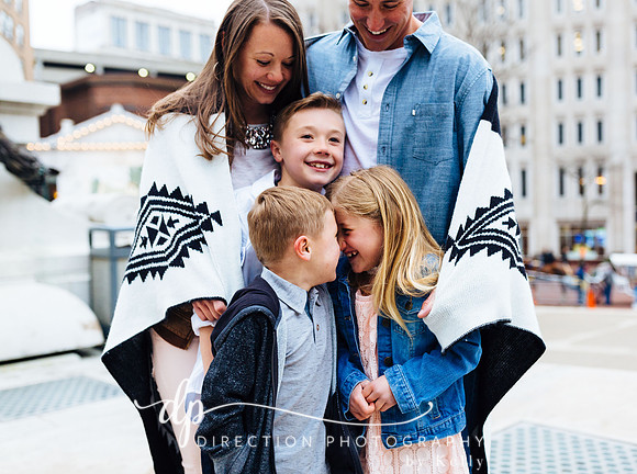 Attractive young family standing on steps in front of Soldiers and Sailors Monument in Indianapolis IN
